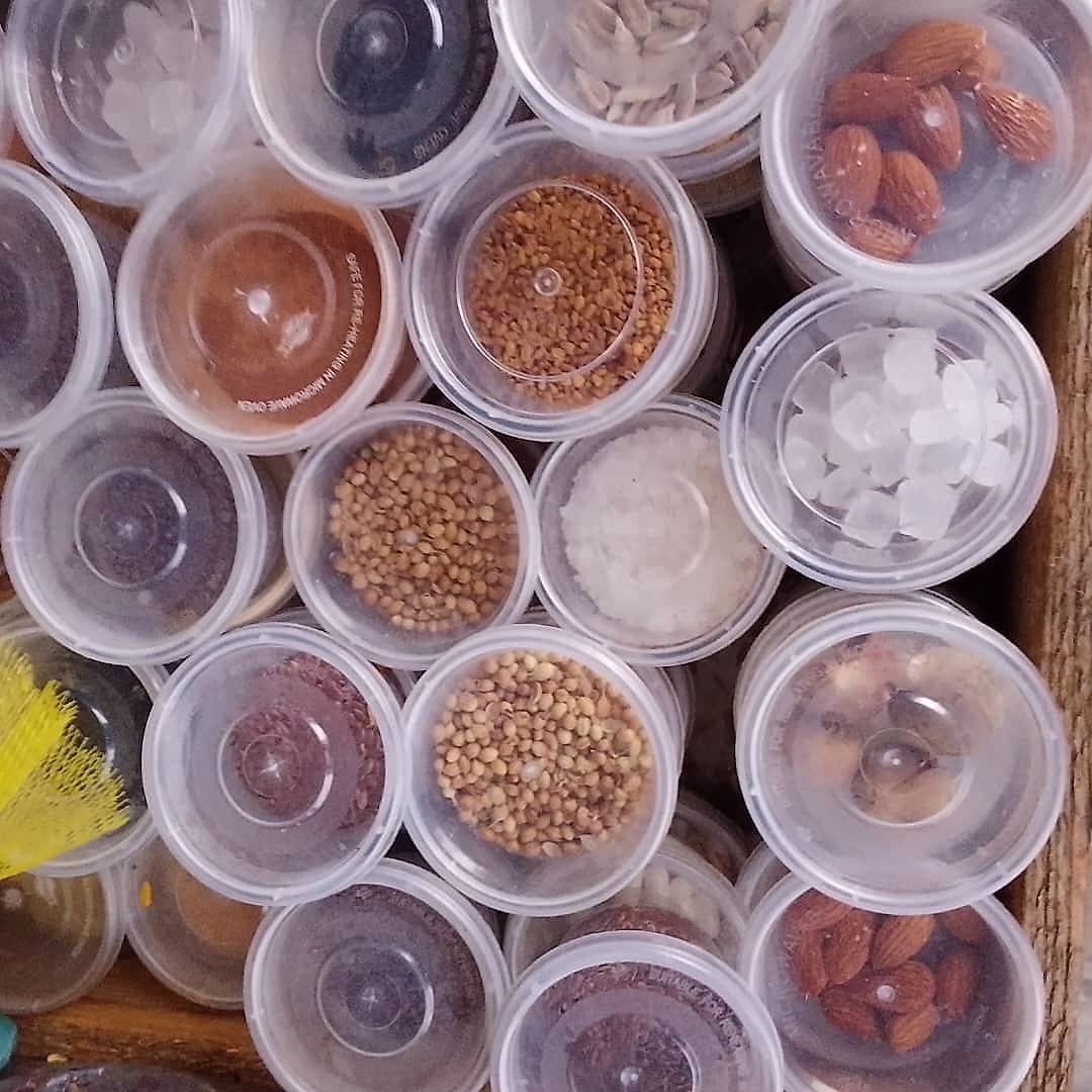 Tubs of local spices including coriander, ground pepper and dried seeds
